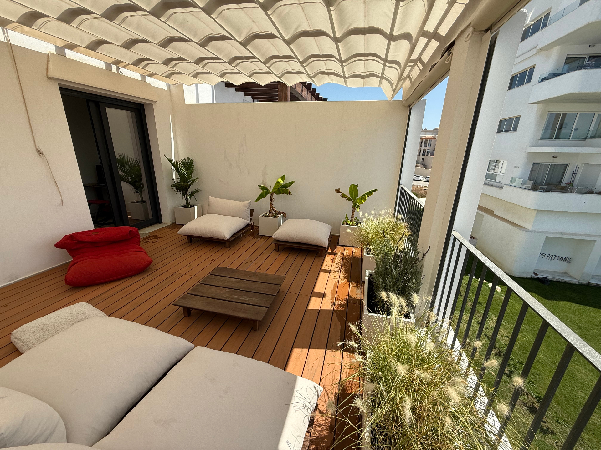 Sun-drenched rooftop terrace with wooden decking and views of Tarifa coastline